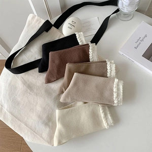 Detail of five pairs of ribbed knit socks with white lace trim in various earthy tones