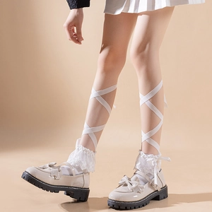 Detail of Mary Jane shoes with double bows and ballet-style lace socks and ribbons