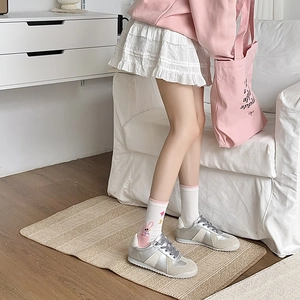 Close-up of white socks featuring cute cartoon rabbit design with retro sneakers