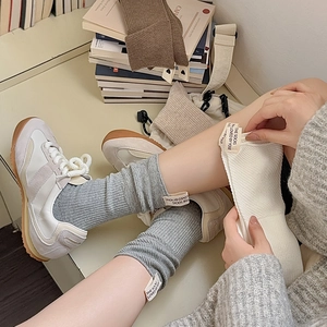 Calze al polpaccio in maglia a coste stile coreano con etichetta e sneaker vintage