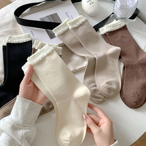 Close-up of ribbed cotton socks with delicate lace trim in neutral earthy colors