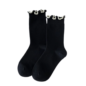 Minimalist black cotton mid-calf socks with white ruffle trim and ribbed texture design