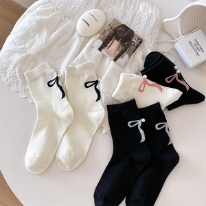 Détail de chaussettes blanches style ballet avec nœud et décoration de perles
