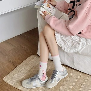 Close-up of white cotton mid-tube socks with cute rabbit and star embroidery detail