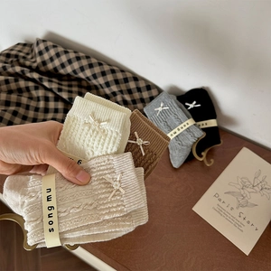 Detailed knit texture and pearl bow accent on vintage-style mid-calf cotton socks