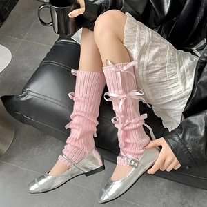 Pink knit leg warmers with ribbons and ribbons paired with silver Mary Jane shoes