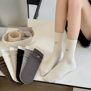 Dettaglio di calze a coste in cotone con fiocco ricamato e varie opzioni di colore eleganti