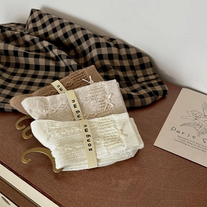 Detail of three-pack bow-knot knit crew socks in earth tones with pearl charms
