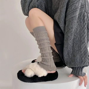 Close-up of grey knitted leg warmers with heart pattern and ruffled hem for JK style