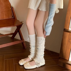 White knit leg warmers with blue bows and matching arm sleeves in ballet style fashion