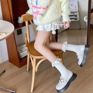 White platform Mary Janes with ruffled trim and lace socks with decorative bows