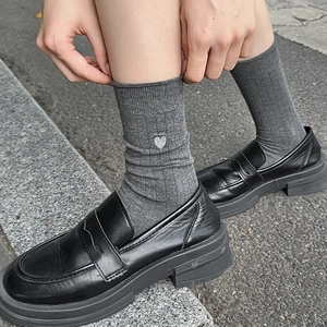 Grey heart embroidery ribbed crew socks styled with black loafers on outdoor pavement