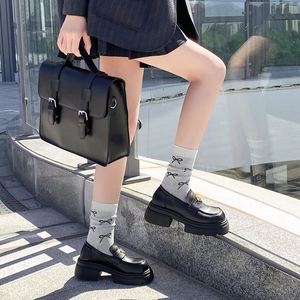 Details von Socken im Ballett-Stil mit Schleife und schwarzen Plateau-Loafern für Look
