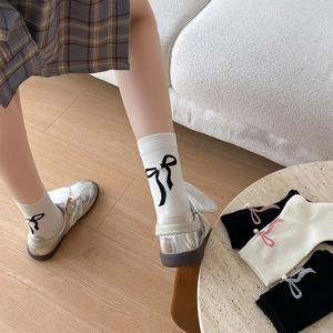 Détail de chaussettes style ballet avec rubans de soie et ornements en perles