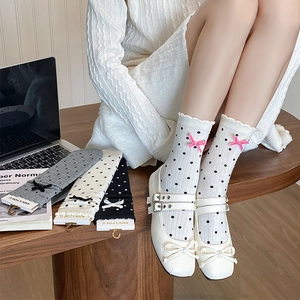Detail of sweet polka dot mid-calf socks with 3D bows and decorative ruffled cuffs