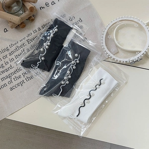 Three-pack of ribbed socks in black, gray, and white with pearl and ruffled embroidery