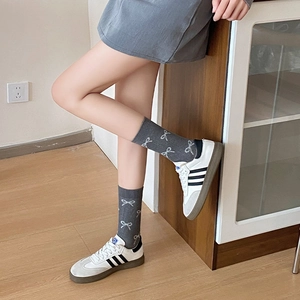 Detail von dunkelgrauen Ballett-Socken mit weißem Schleifenmuster und Rippstrick-Textur