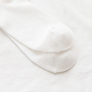 Close-up of fine knit texture and reinforced toe seam on white cotton mesh lace socks