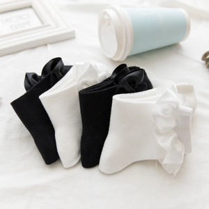 Detailed close-up of lace-trimmed socks with silky bows in black and white styles