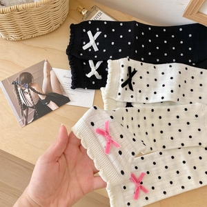 Detail of sweet polka dot socks featuring delicate bow accents and ruffled cuffs in soft cotton