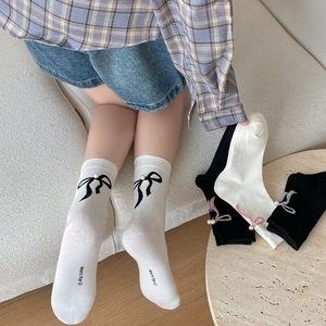 Détails de chaussettes blanches style ballet avec nœuds délicats et perles décoratives
