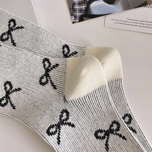 Nahaufnahme von Ballett-Stricksocken mit schwarzen Schleifenmustern und feiner Rippstruktur