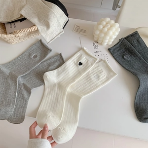 Detailed view of striped cotton socks with heart embroidery in a variety of soft colors