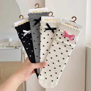Close-up of polka dot socks featuring lace edges and velvet bow details in a four-color set