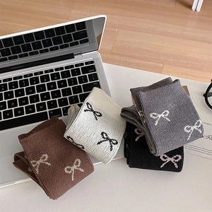 Detaillierte Strickstruktur von Socken im Ballettstil mit Schleife in Braun, Beige und Grau