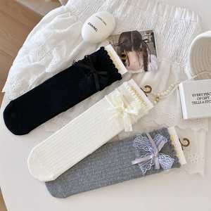 Detailed view of three pairs of cotton lace socks with silk bows in black, white, and grey