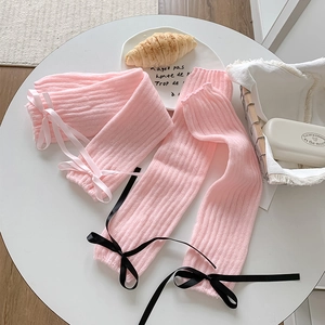 Détails du tricot de jambières roses avec des accents élégants de nœuds en satin