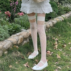 Detail of white lace over-knee socks featuring floral jacquard and hollow out stripes