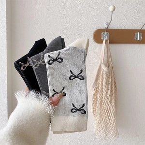 Detailaufnahme der Jacquard-Stricksocken mit Schleifenmuster in Schwarz, Grau und Beige