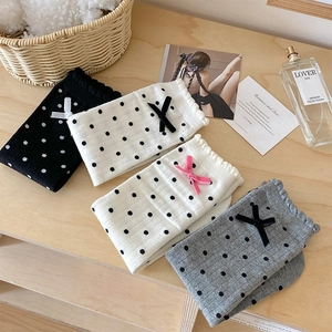 Detailed flat lay of polka dot socks with ribbons on a light wooden surface