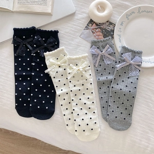 Detailed flat lay of lace trim polka dot socks with bows in black, beige and grey