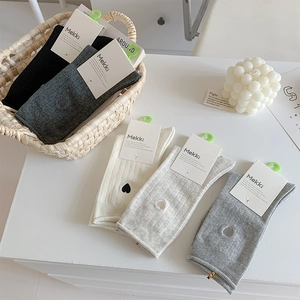 Detailed set of knit crew socks with heart embroidery in neutral colors and Mekki tags