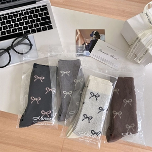 Draufsicht auf vier Paar Ballet-Schleifen-Socken in neutralen Farben mit edler Geschenkverpackung