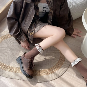 Close-up of brown striped cotton socks with white lace trim and retro platform leather shoes