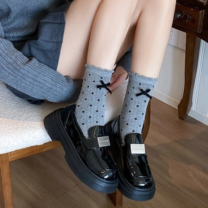 Black patent leather platform loafers with silver buckle and gray polka dot socks