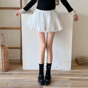 Close-up of white ruffled lace socks with black bow accents and Mary Jane shoes