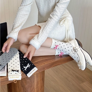 Close-up of sweet polka dot mid-calf socks with cute bow accents and ribbed cuffs