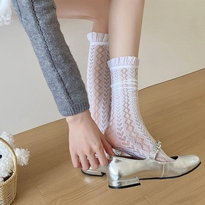 Close-up of white lace mesh socks with heart patterns and double ruffle lace trim