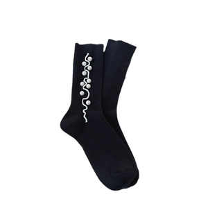 Black crew socks with ruffled edges and pearl embellishments in retro sweet style