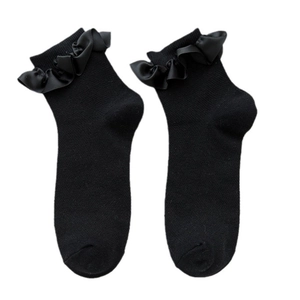 Black Japanese style lace socks with satin ruffle trim displayed on a flat white background
