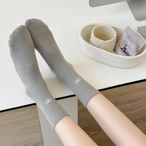 Calze grigie a coste verticali con ricamo a fiocco bianco per la moda autunno donna