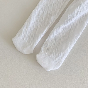 Close-up of white mesh hollow-out over-knee socks with intricate floral texture details