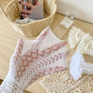 Detail of white mesh lace socks showing diamond cutout texture and ruffled trim