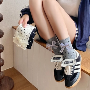 Detail of polka dot crew socks with lace bows and ruffled edges in three colors