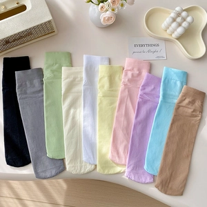 Flat lay of ten candy-colored velvet crew socks in a cozy aesthetic home setting