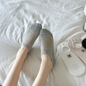 Detail of breathable mesh low cut socks with delicate embroidered bow patterns